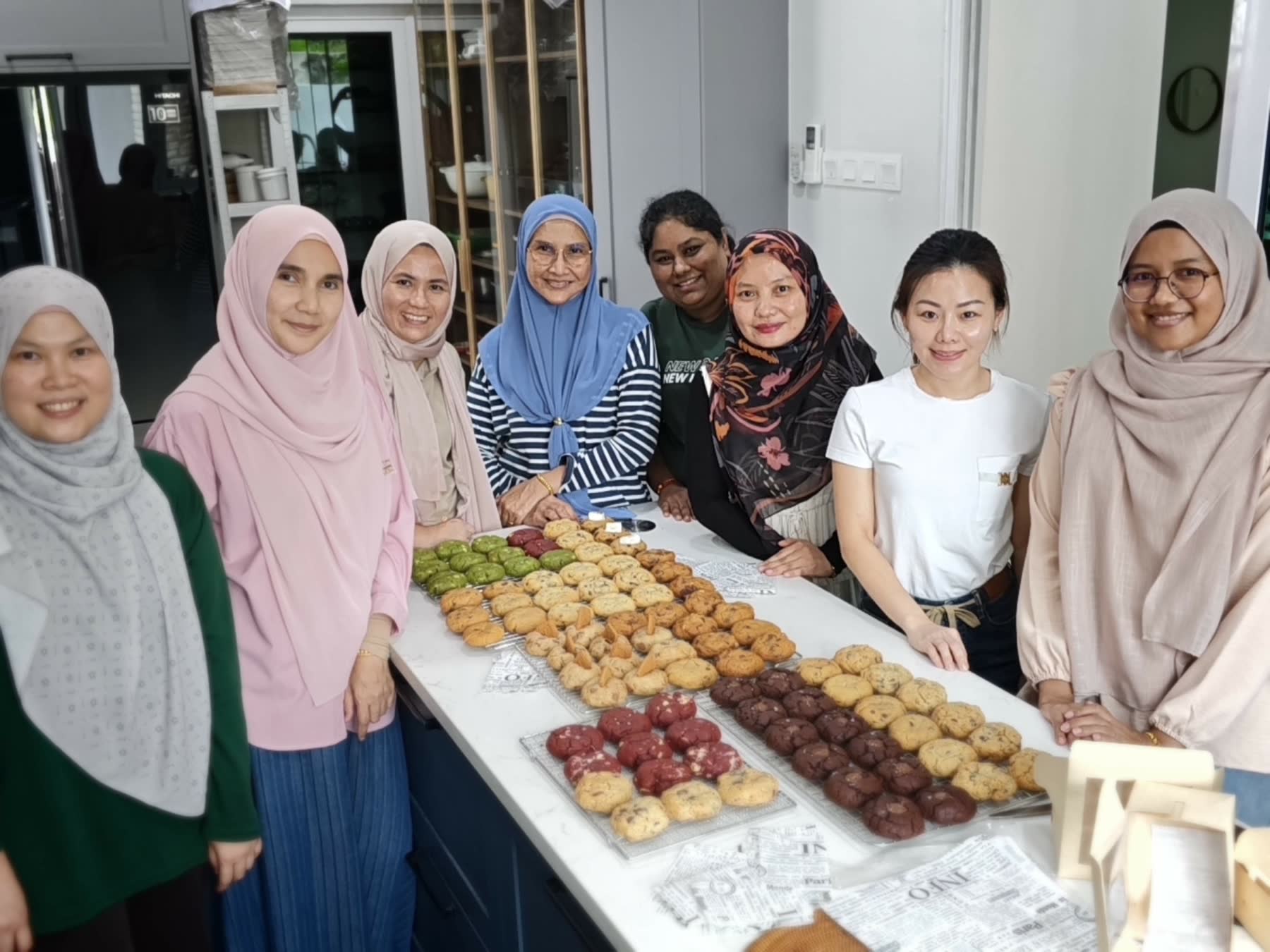 CooknShare members behind a kitchen counter covered in trays of freshly baked cookies